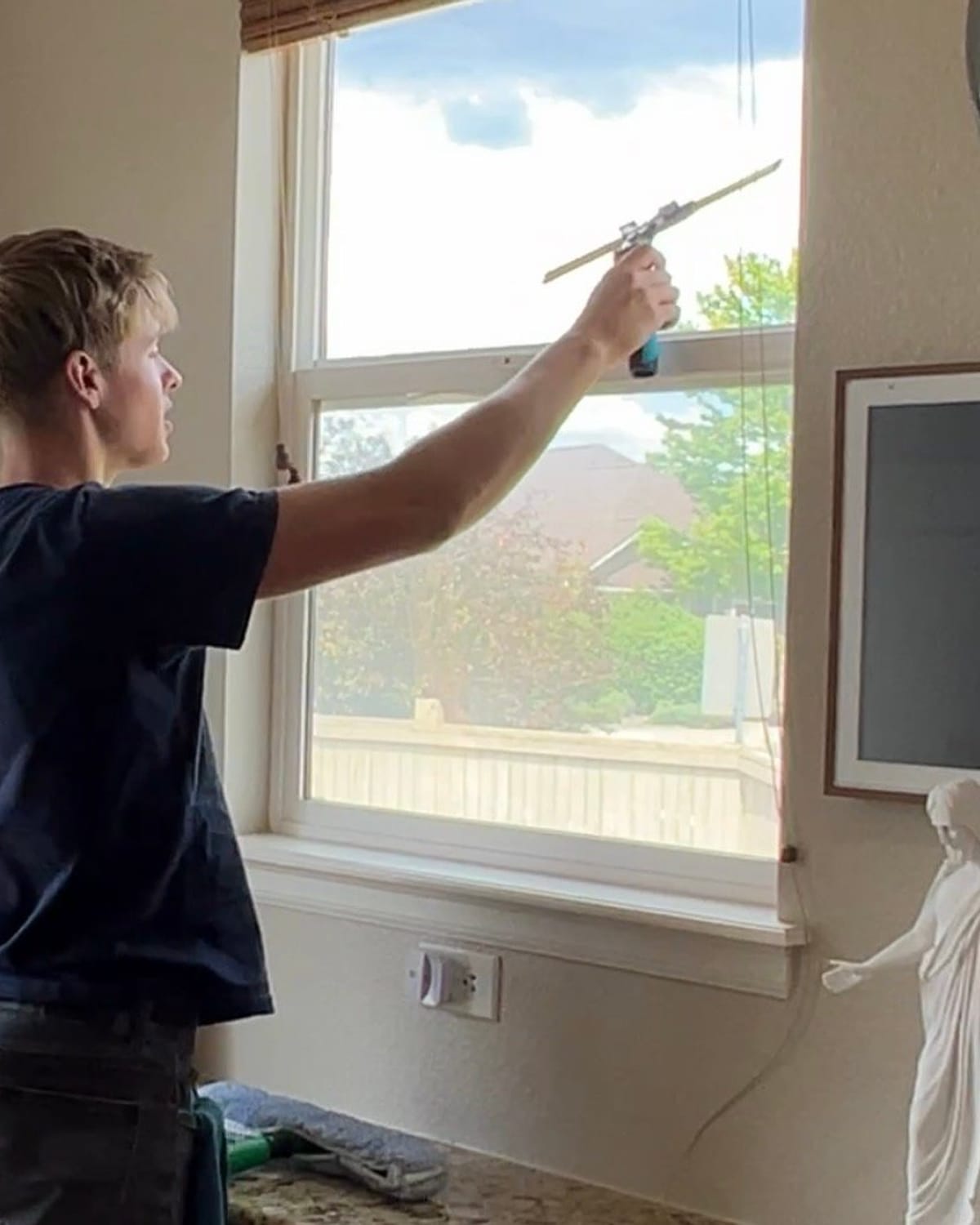 The owner of Butler's ClearView cleaning an interior window at a Parker, CO home