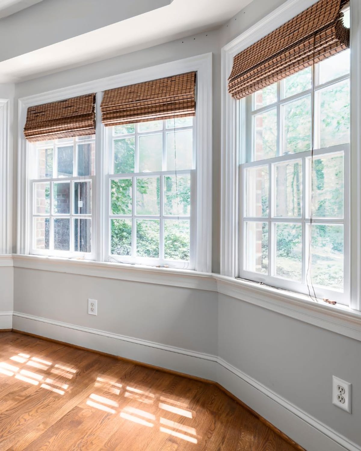 Cleaner wiping down an interior home window pane with a cloth