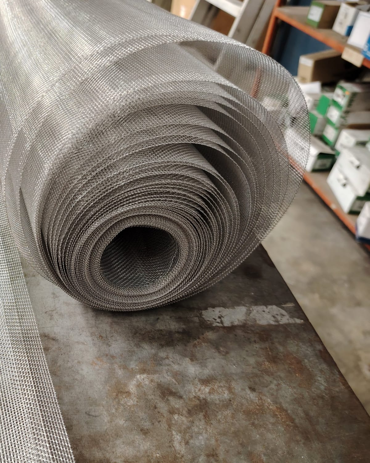 Rolls of fresh aluminum screen mesh in the shop, ready for re-meshing jobs